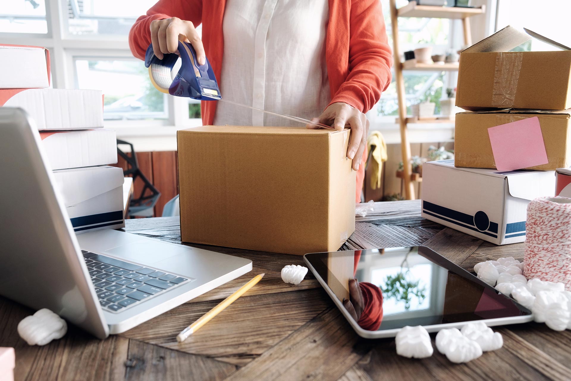 online sales woman packing a carton